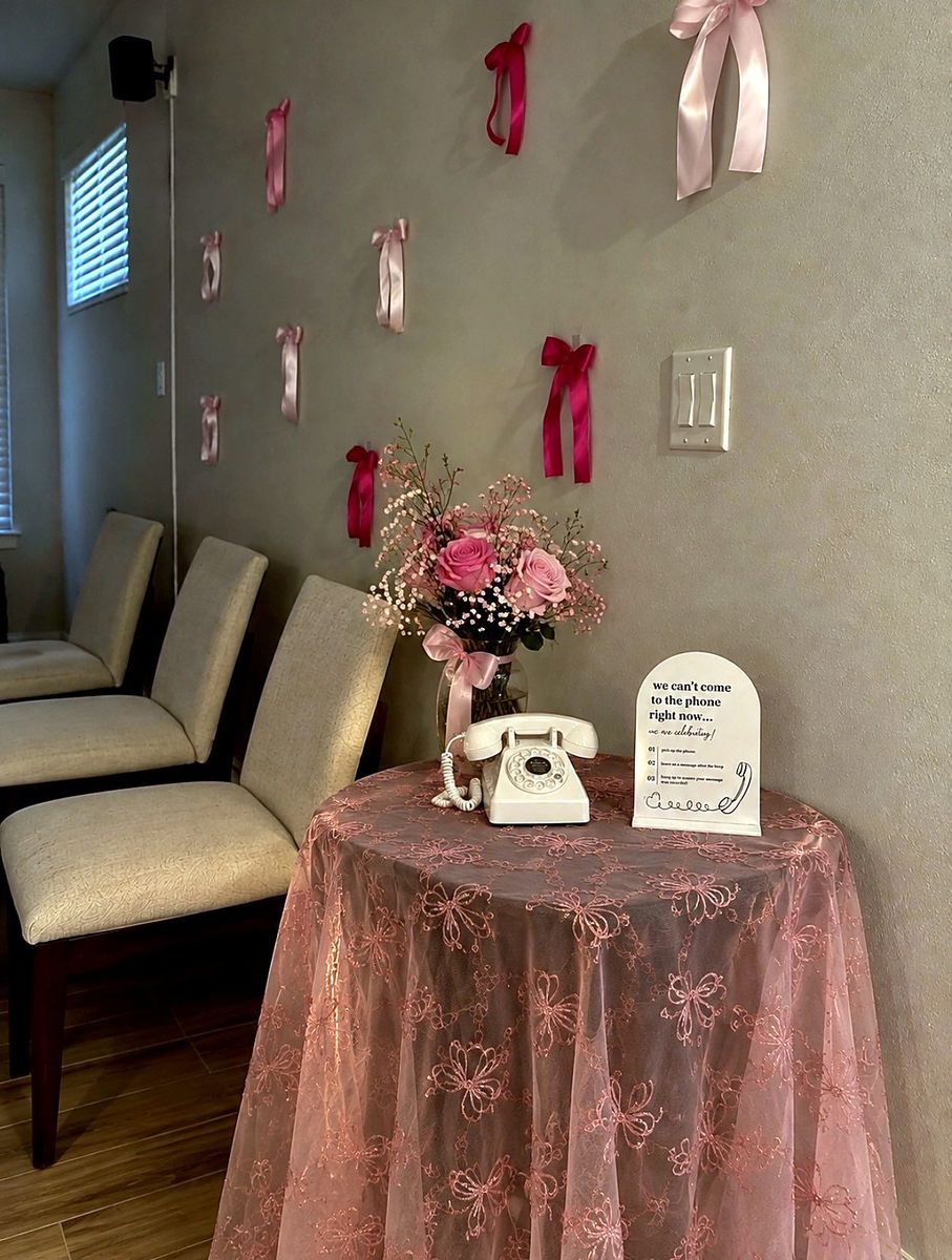 Phone on a pink lace table with bows and roses
